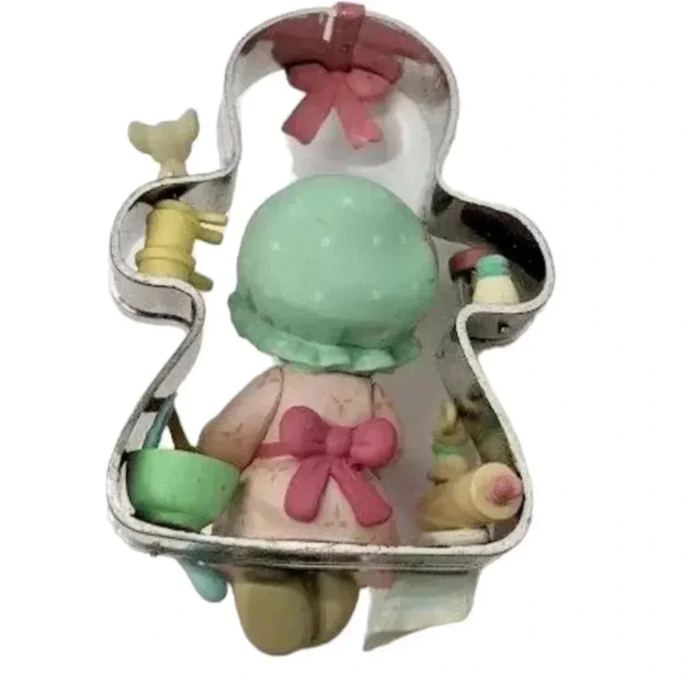 Precious moments girl perched on a cookie cutter christmas ornament